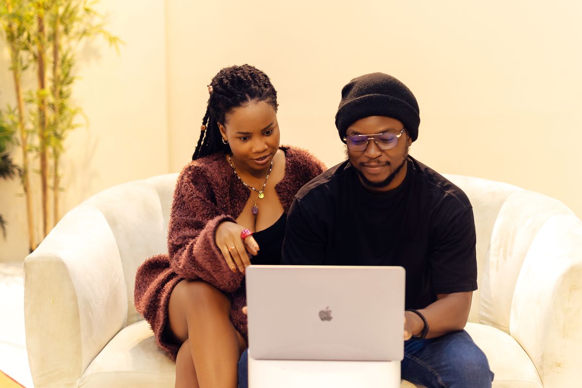 African business colleagues collaborating on laptop indoors in Lagos, Nigeria